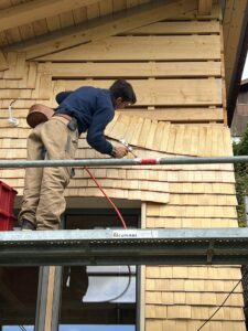 Romain Poulet posant du tavaillon en suivant un motif décoratif.